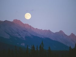 Raymond Gehman The Full Moon Over Mountains Lit by Low Sunlight